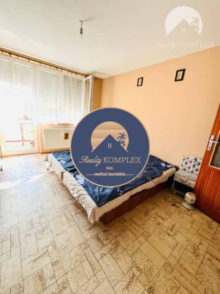 Bedroom in a family house with a bed and a large window, floor with wood decor.