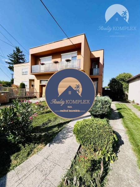 A family house in Okoč with a landscaped garden and a balcony in a pleasant environment.