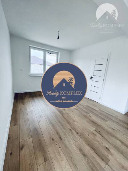 A room with white walls and a wooden decor floor in a family house.