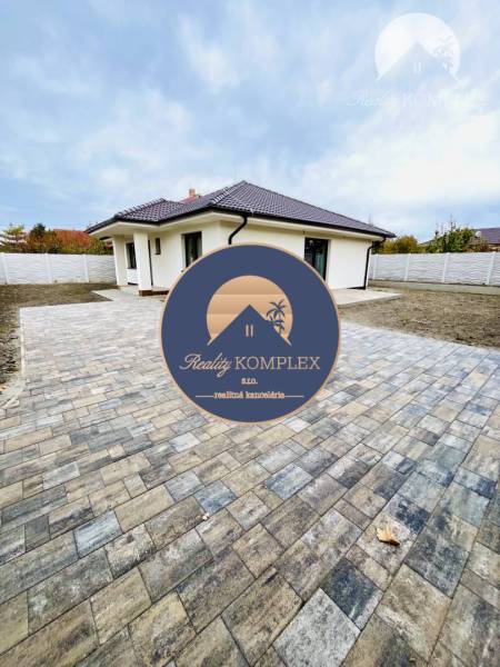 A family house in Topoľníky with a paved area and a roof with dark tiles.