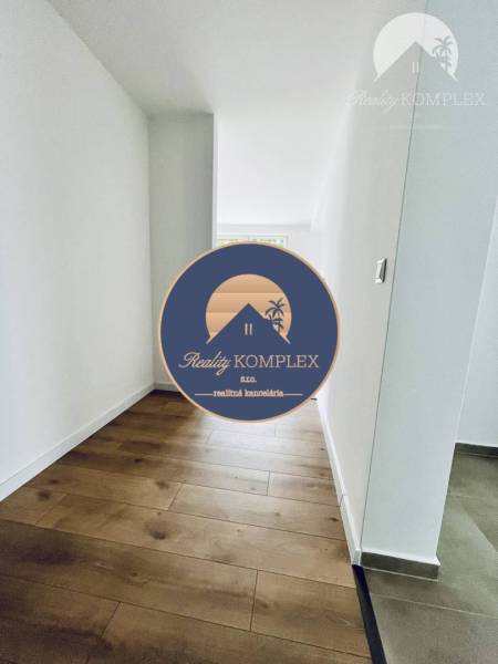 A hallway in a family house with a wooden decor floor and white walls.