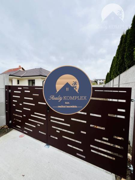 A gate in front of a family house in Topoľníky with a design of horizontal openings.