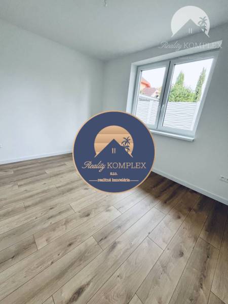 White room with wood-patterned flooring in a family house.
