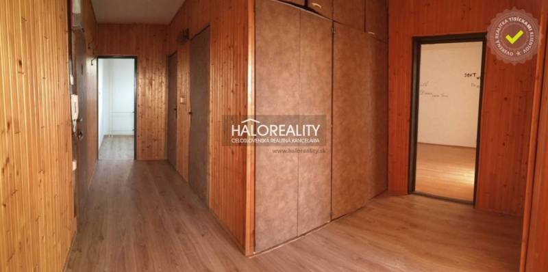 Hallway of a 4-room apartment with wooden paneling and flooring with a wood decor.
