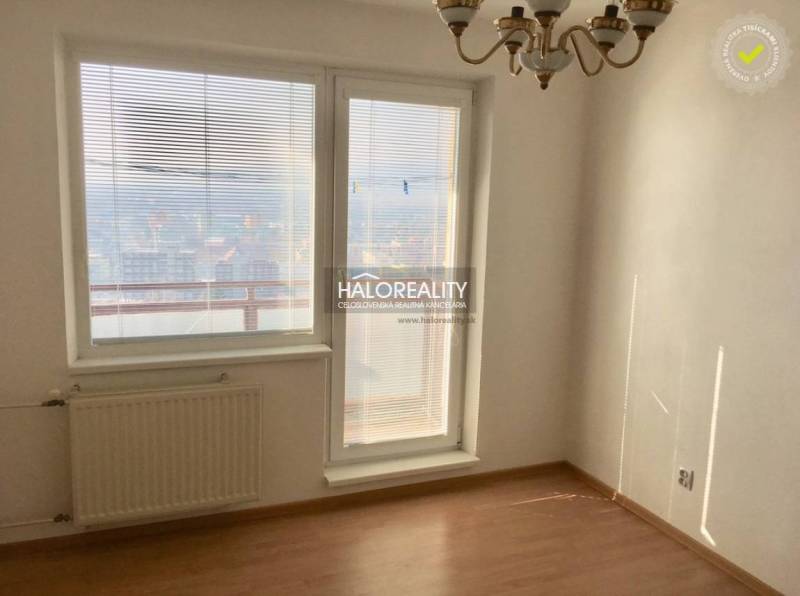 A room with a radiator, a wooden decor floor, and a view in a 4-room apartment.