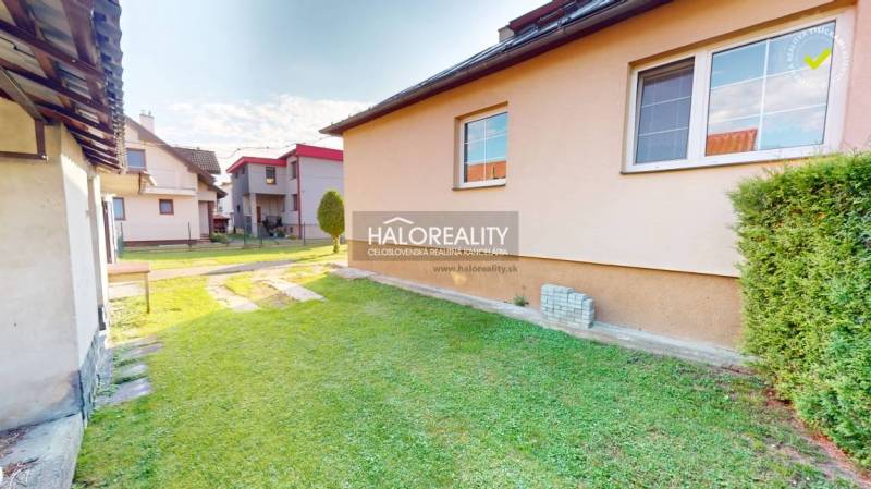 The garden of a family house in Krasňany with a lawn, next to it are other houses.