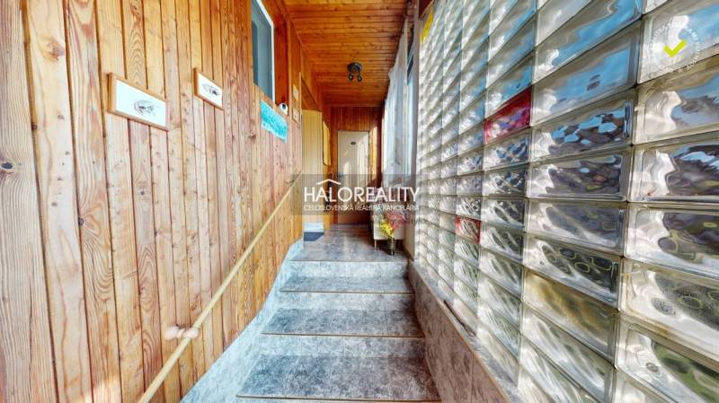 Interior of a family house with tiles, wooden paneling, and a glass wall.