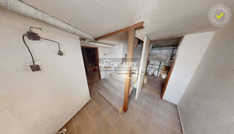 Basement of a family house with a classic staircase, rooms, and storage spaces, white walls.