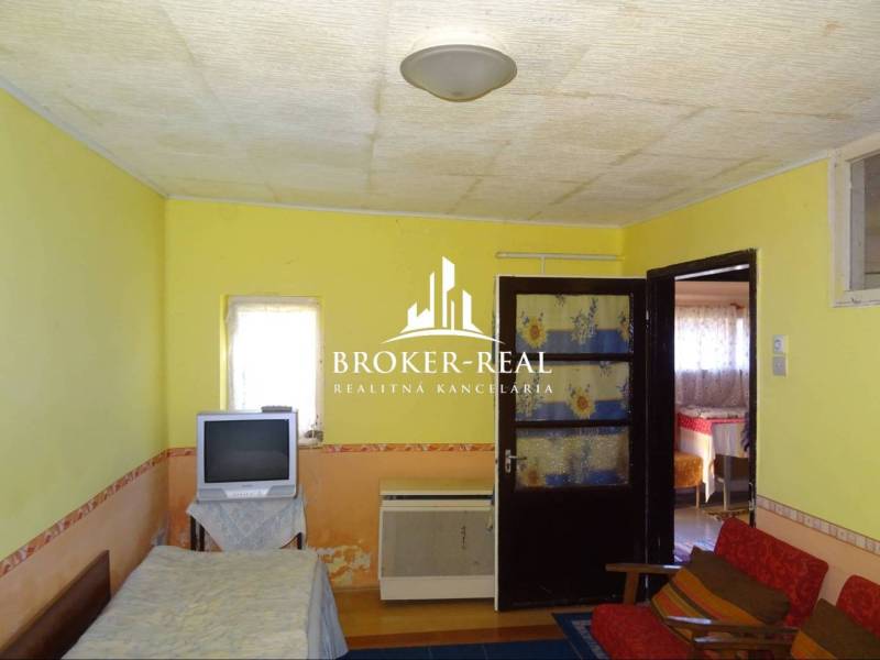 Living room in a family house with a television and double doors.