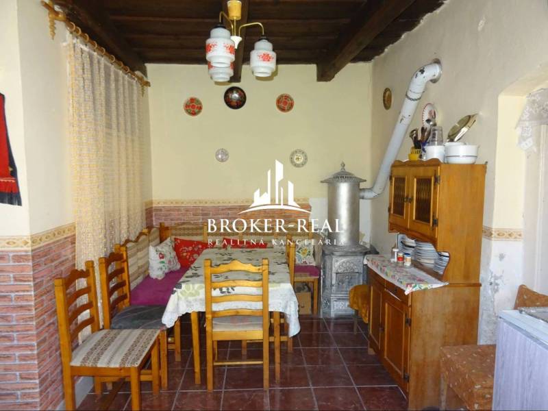 A rustic kitchen in a family house with tiles, wooden furniture, and ceramic decorations.