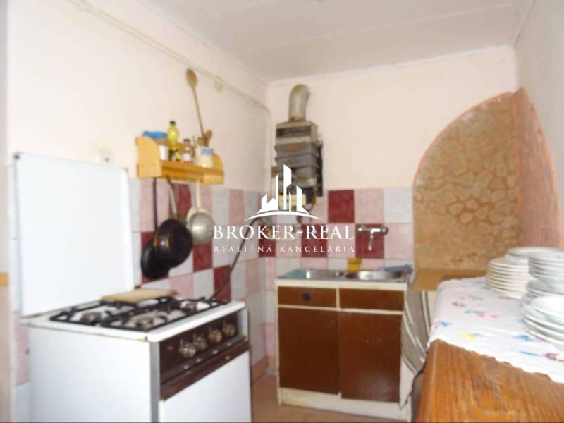 A kitchen in a family house with a gas stove and ceramic tiles on the wall.