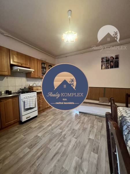 A kitchen in a family house with a wooden decor floor and wooden furniture.