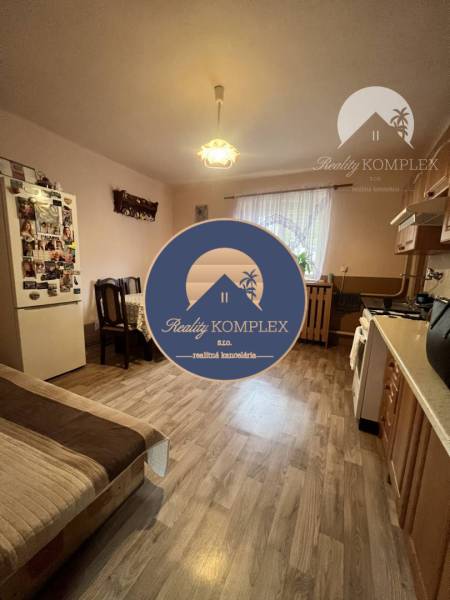 A kitchen in a family house with a wooden decor floor, a table, and a sofa set.