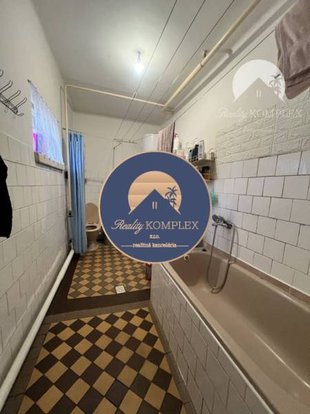 A bathroom in a family house with a bathtub and mosaic tiles offers a cozy atmosphere.