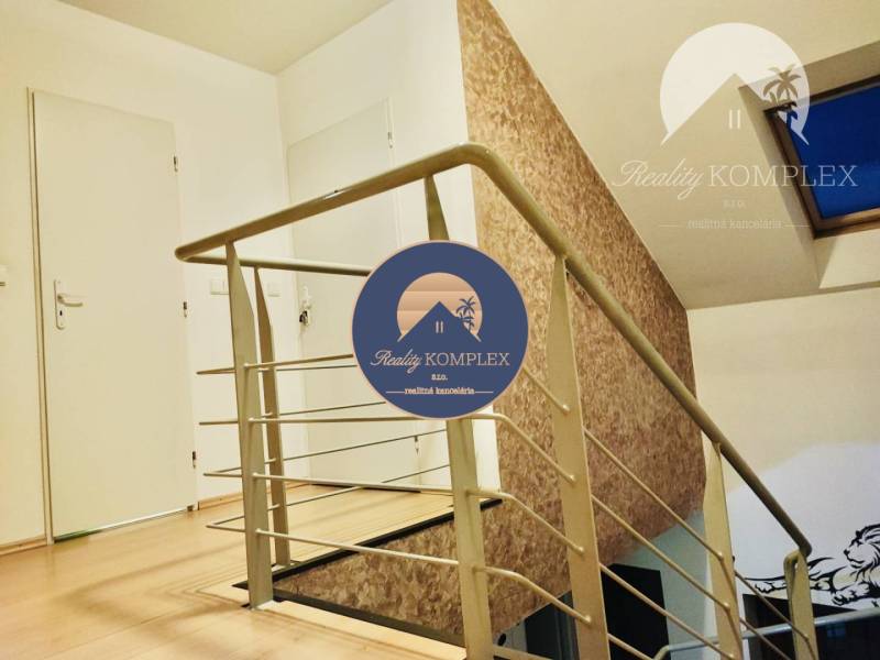 A staircase with a metal railing and a wooden decor floor in a family house.