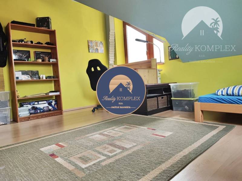 Attic room in a family house with wooden floor decor, colorful walls, and a carpet.