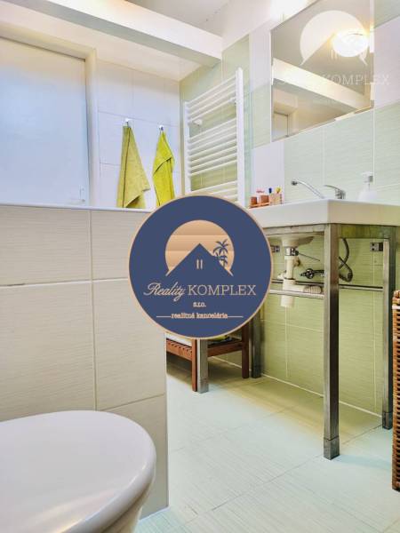A bathroom in a family house with a sink, towels, and a radiator on the walls.