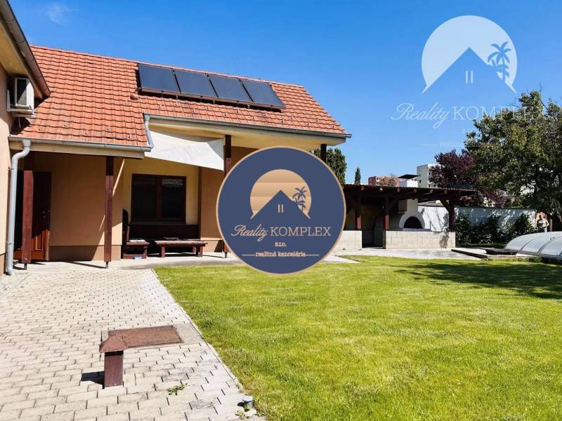 A family house in Komárno with a terrace, solar panels, and a swimming pool in the garden.