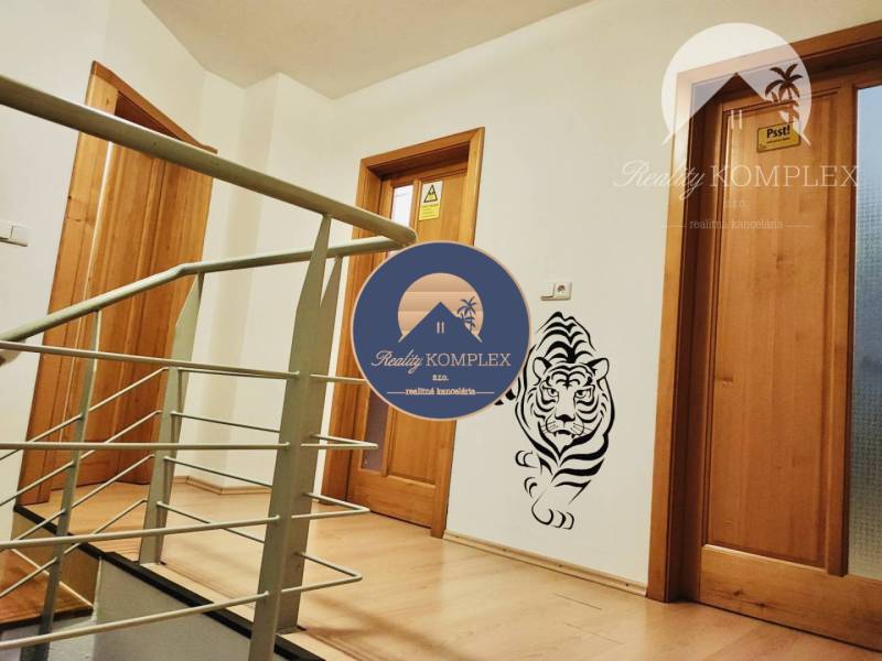 A hallway of a family house with wooden decor and a tiger decoration on the wall.