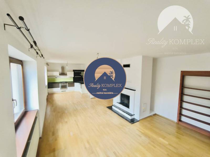 A family house with a kitchen, a fireplace, and a floor with a wooden decor.