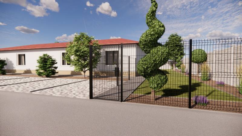 A family house in Zemianska Olča with a landscaped garden and decorative trees behind the fence.