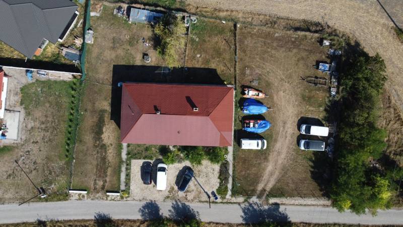Aerial view of a family house in Zemianska Olča with a spacious yard and parked cars.