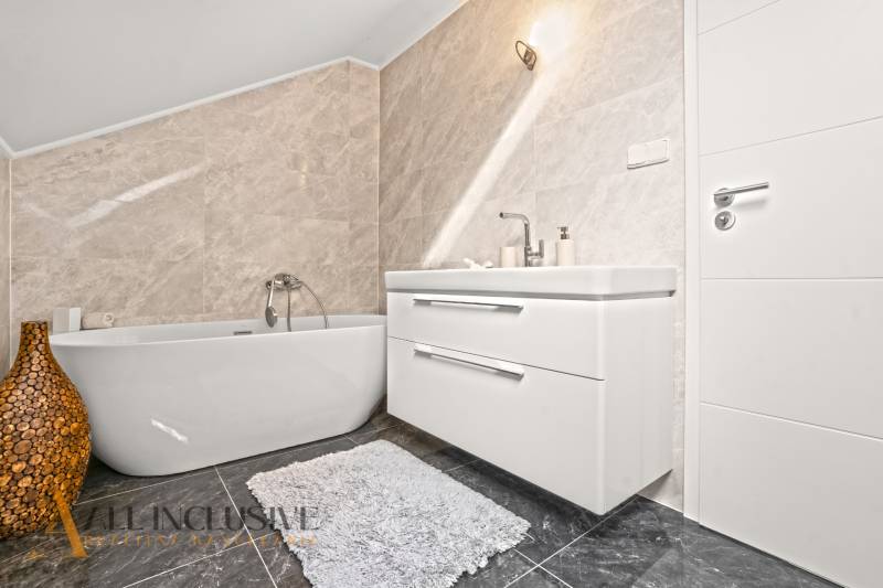A bathroom in a family house with a freestanding bathtub and a modern sink.