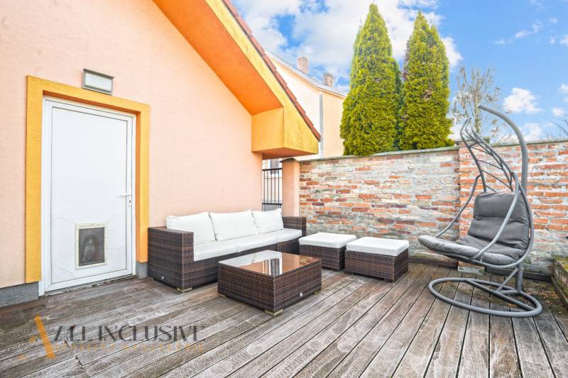 The terrace of a family house in Dobrohošť with outdoor seating and a floor with a wooden decor.