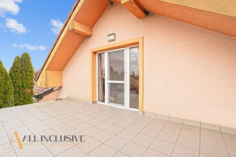 The terrace of a family house in Dobrohošť with paving and ornamental trees.