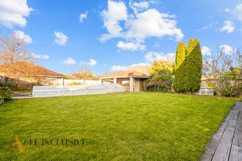 The garden of a family house in Dobrohošť with a lawn, a small pool, and a terrace.