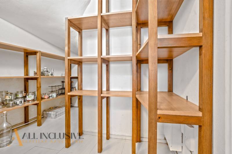 Wooden storage shelves in a cozy room of a family house with white walls.