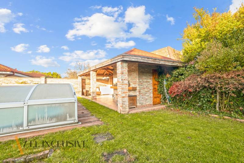 The garden of a family house in Dobrohošť with a covered swimming pool and a gazebo.