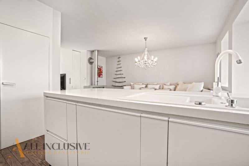 Interior of a family house with a marble counter, chandelier, and floor with a wood decor.