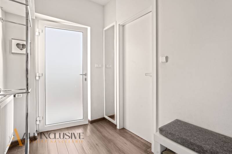 Interior of a family house with white doors and a floor with a wooden decor.