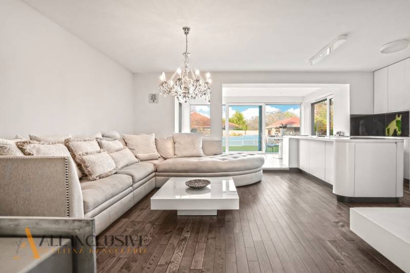 Interior of a family house with a sofa, chandelier, and wooden decor flooring.