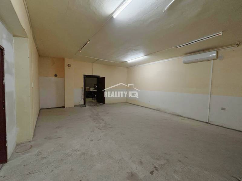 A spacious room in a family house with simple lighting and light-colored walls.