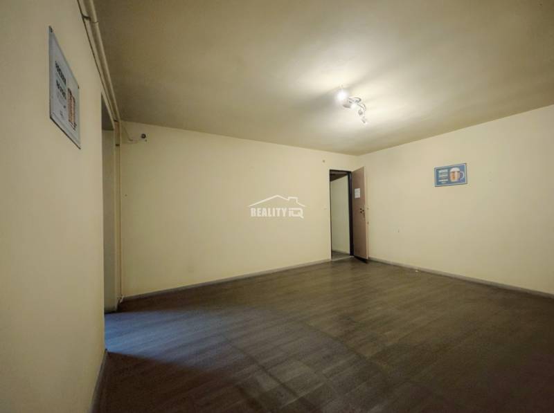 A room with a wooden decor floor and white walls in a family house.