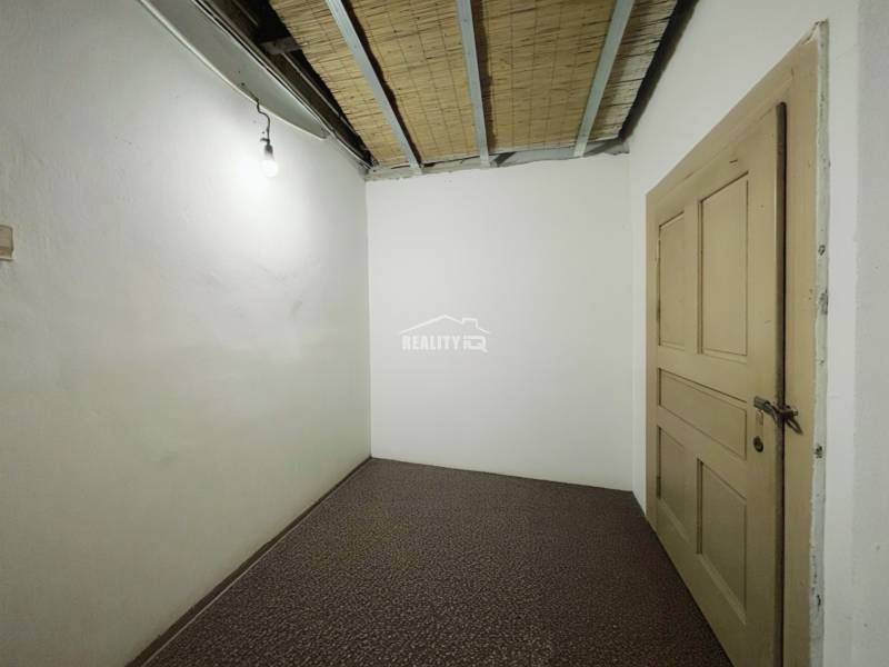 A simple room in a family house with white walls and brown doors.