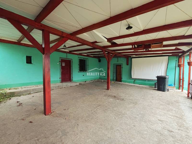 A spacious terrace of a family house in Kolárovice with a covered roof and a projection screen.