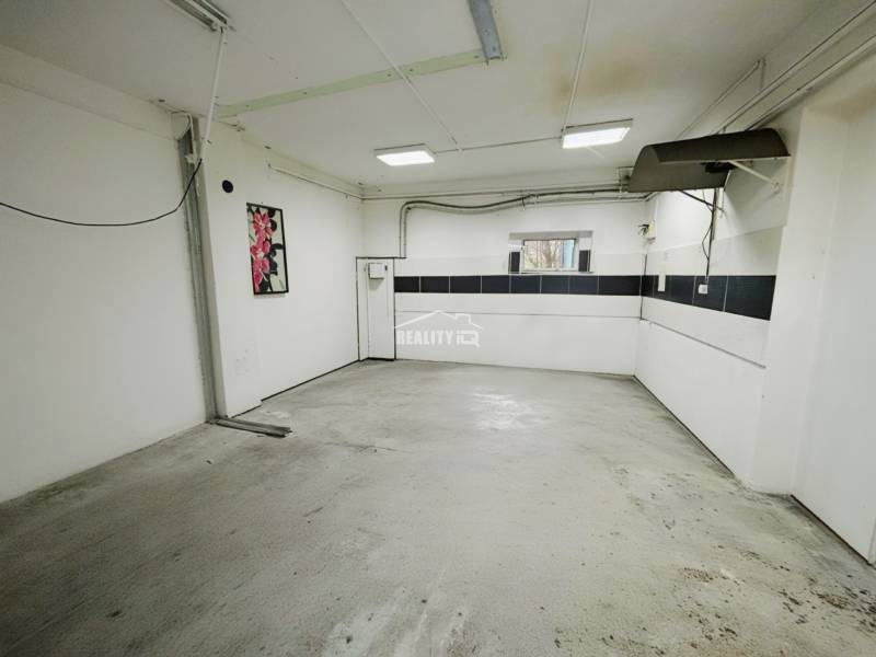 The interior of a garage in a family house, white walls, window, concrete floor.