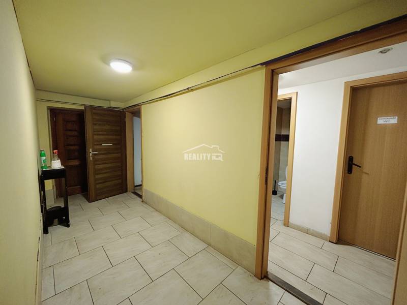 A hallway in a family house with doors and a floor made of ceramic tiles.