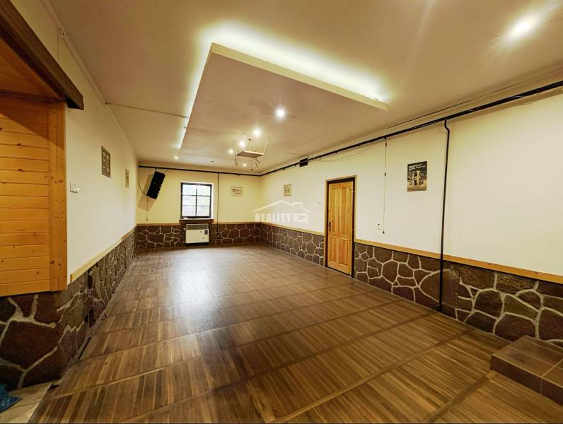 A decorated room with a wooden decor floor, stone, and wooden elements in a family house.