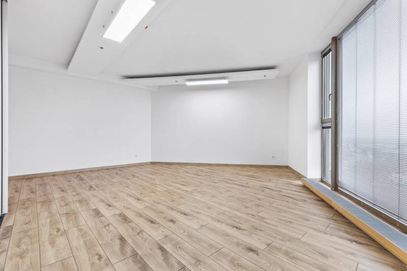 Spacious room with wooden decor flooring and a large window in a 3-room apartment.