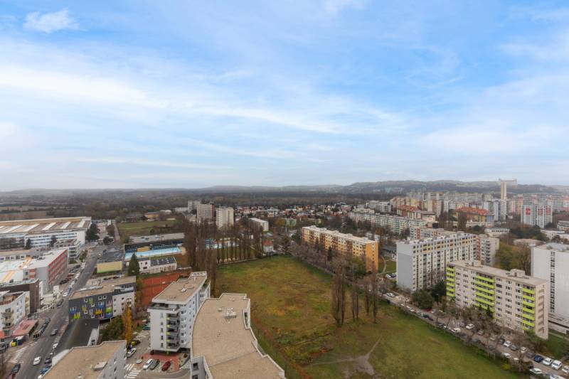 The view of Petržalka shows a housing estate with apartment buildings and open space.