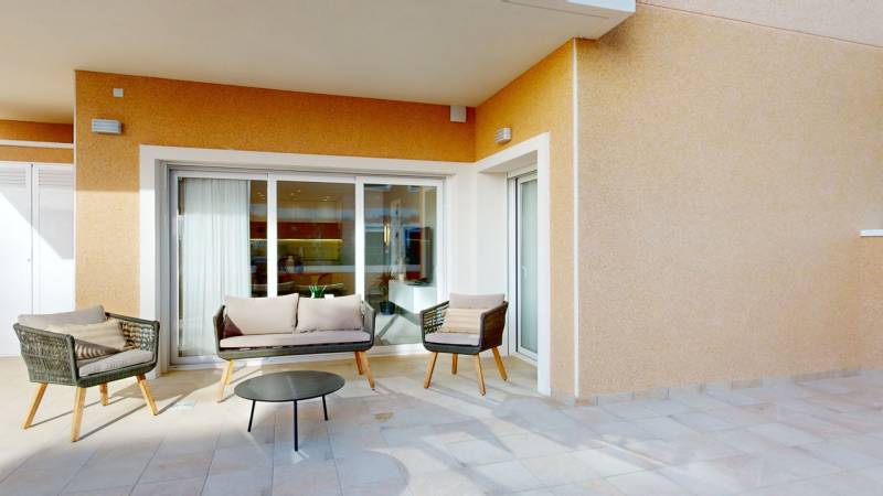 Terrace in a holiday apartment in El Raso with comfortable seating and a table.