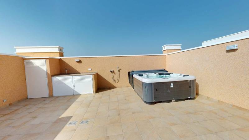 Rooftop terrace of a holiday apartment in El Raso with a hot tub and sink.