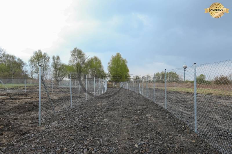 Plots - housing on Nad potokom street in Zohor, fenced area, trees in the background.
