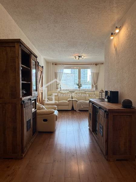 Living room in a 3-room apartment with a wooden decor floor and a comfortable sofa set.