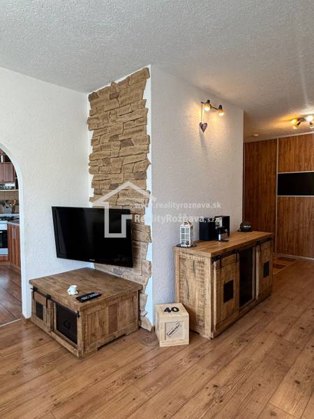 Wooden decor in a 3-room apartment with natural stone and a wall-mounted television.