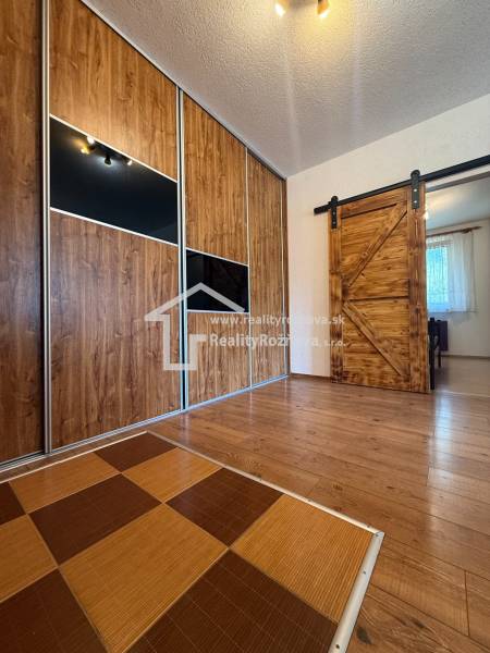Two-tone floor with wood decor and sliding doors in a 3-room apartment.
